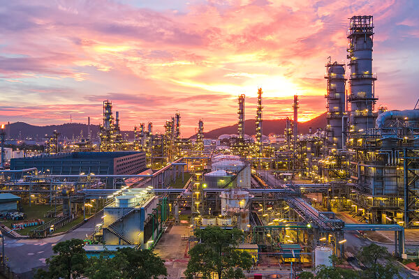 Industrial oil and gas refinery piping system at dusk